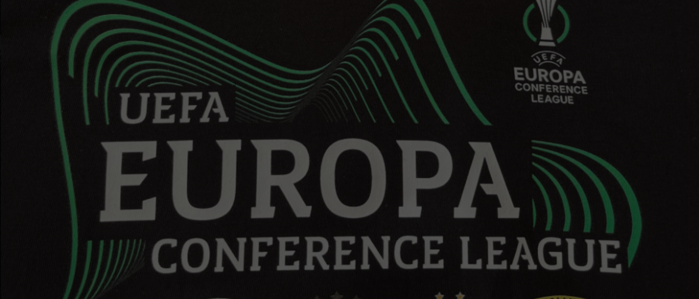 Ztmavená fotografie detailu loga UEFA Europa Conference League aplikovaného na textil